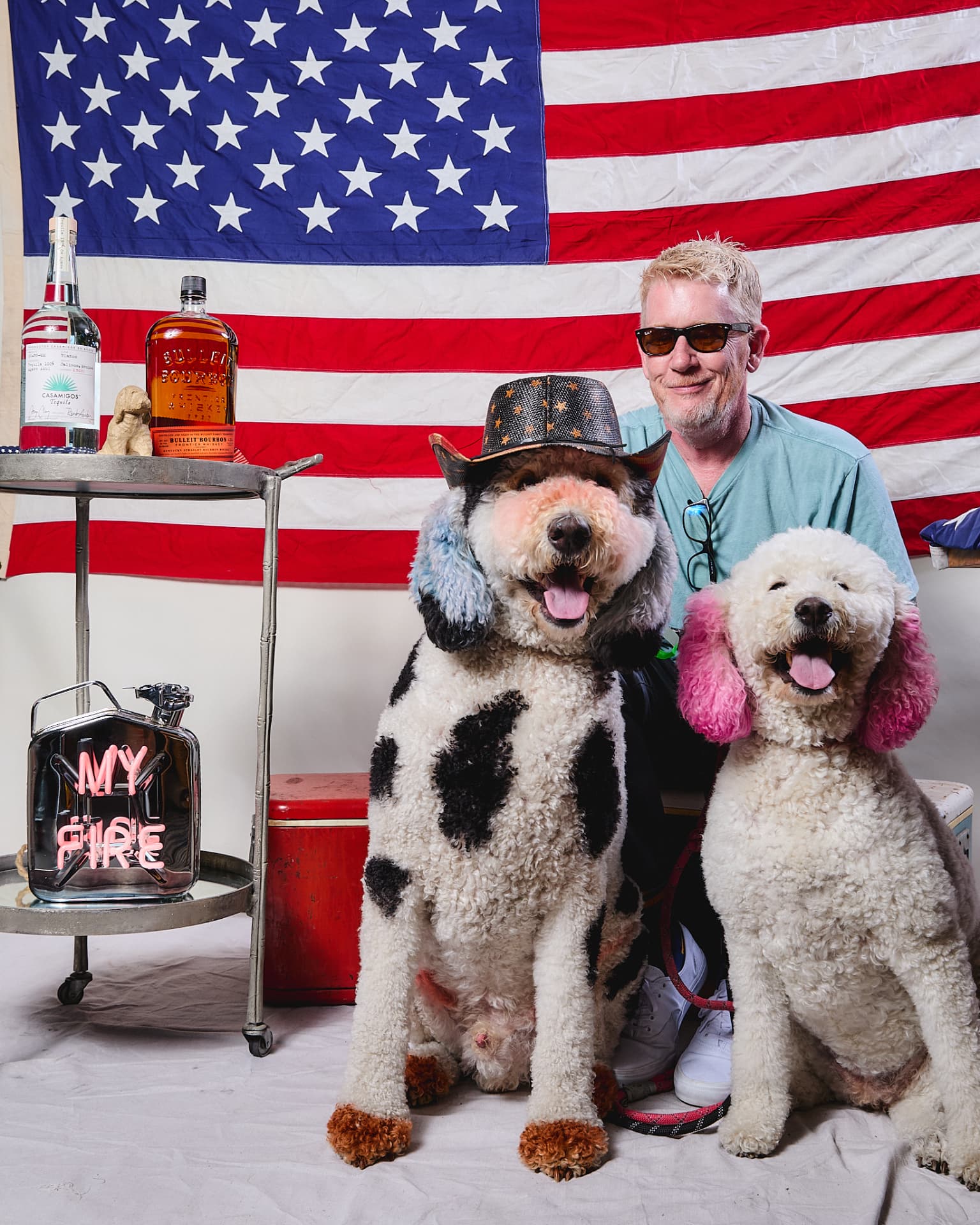 Pet parent with two doodles in front of an American flag