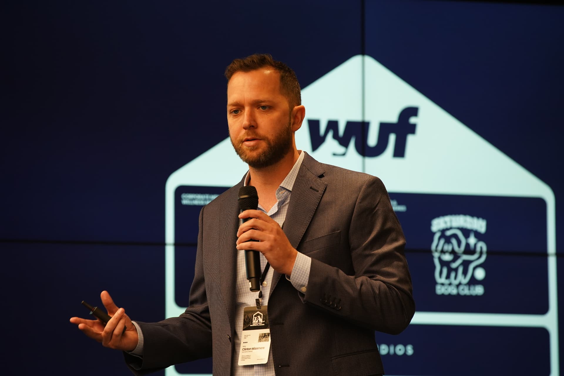 WUF leader speaking with microphone in front of the WUF envelope logo