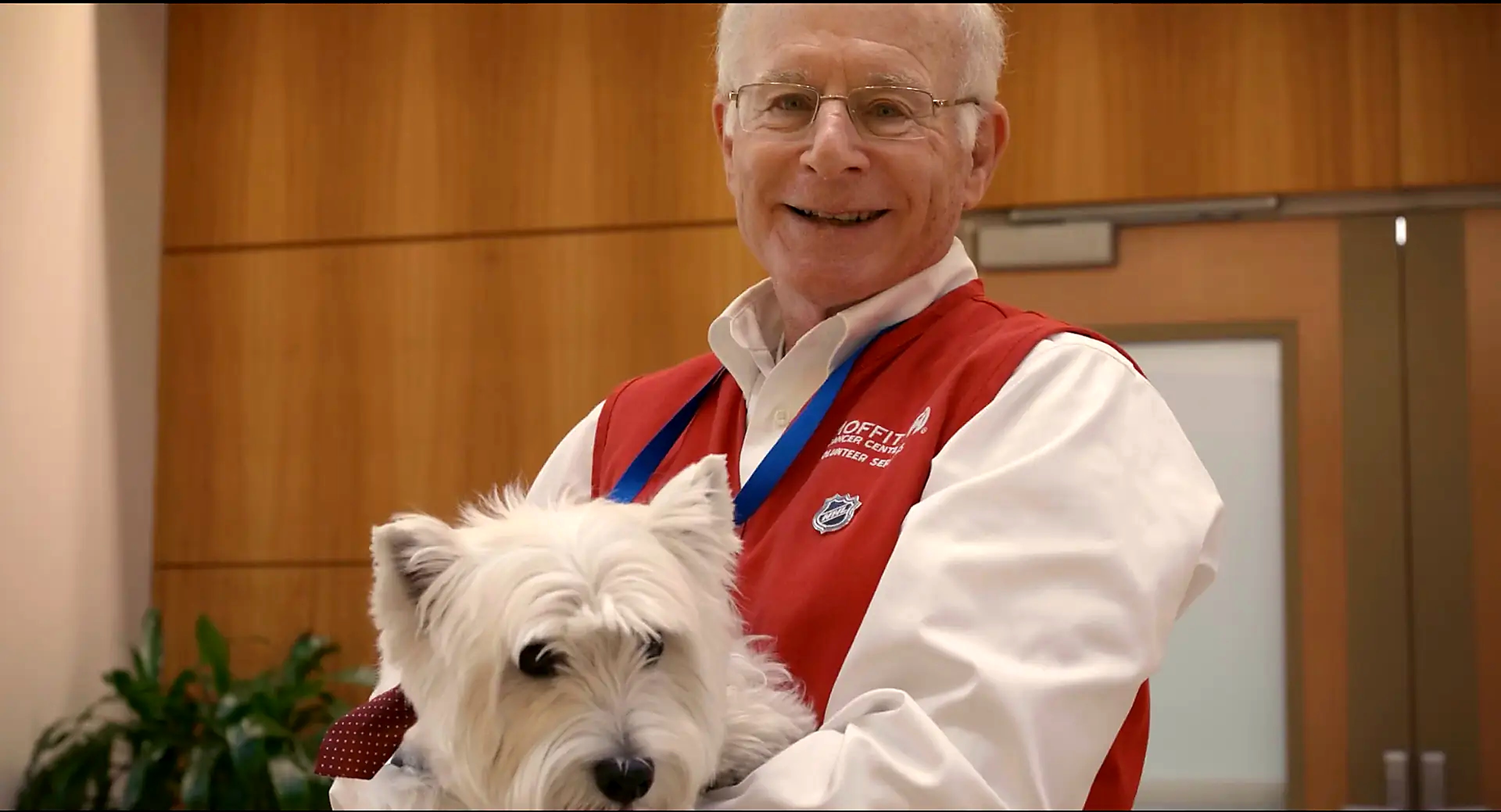 Moffitt Cancer Center volunteer holding a west highland terrier