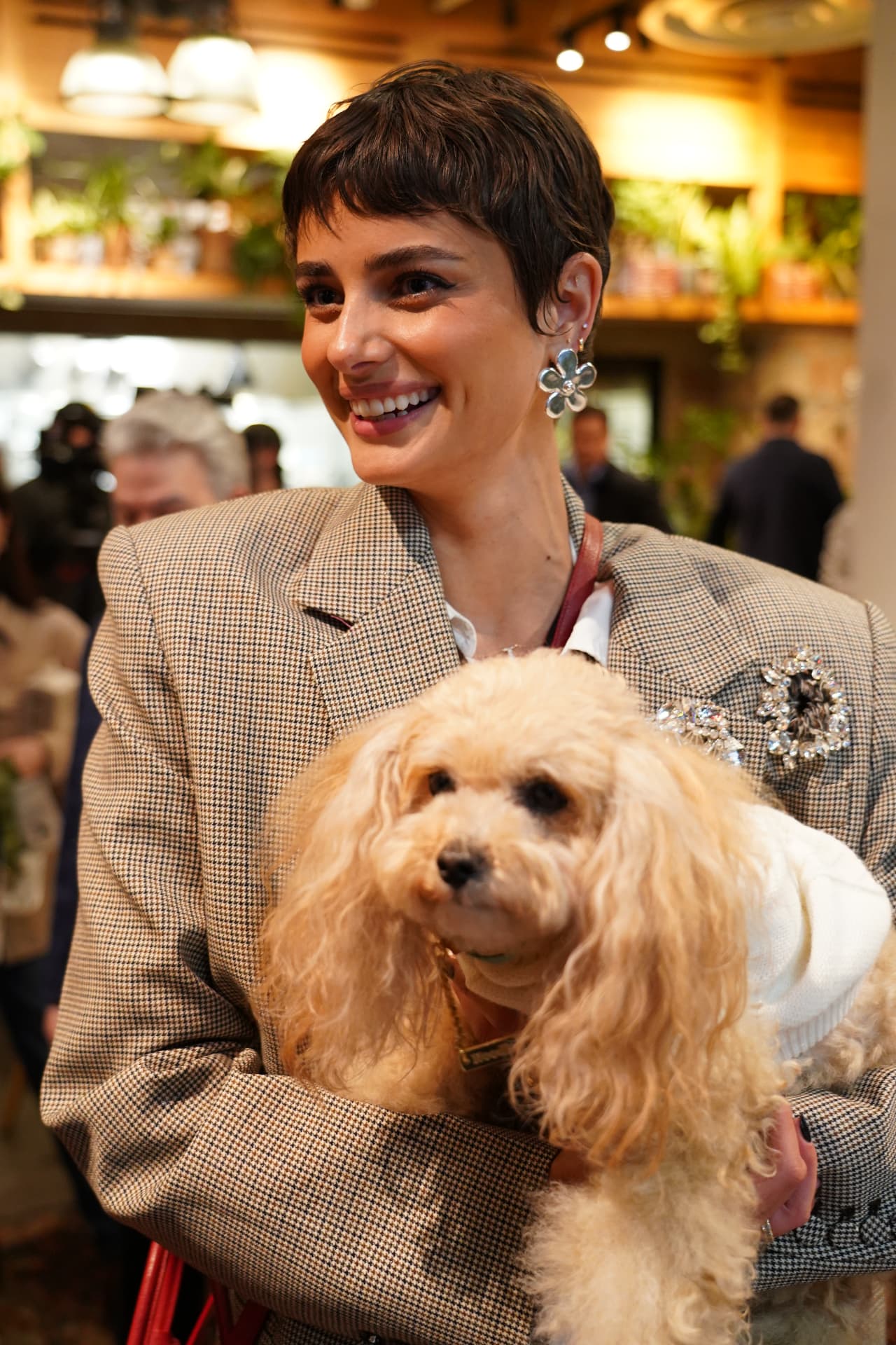 Guest smiling while holding her small poodle at the summit reception