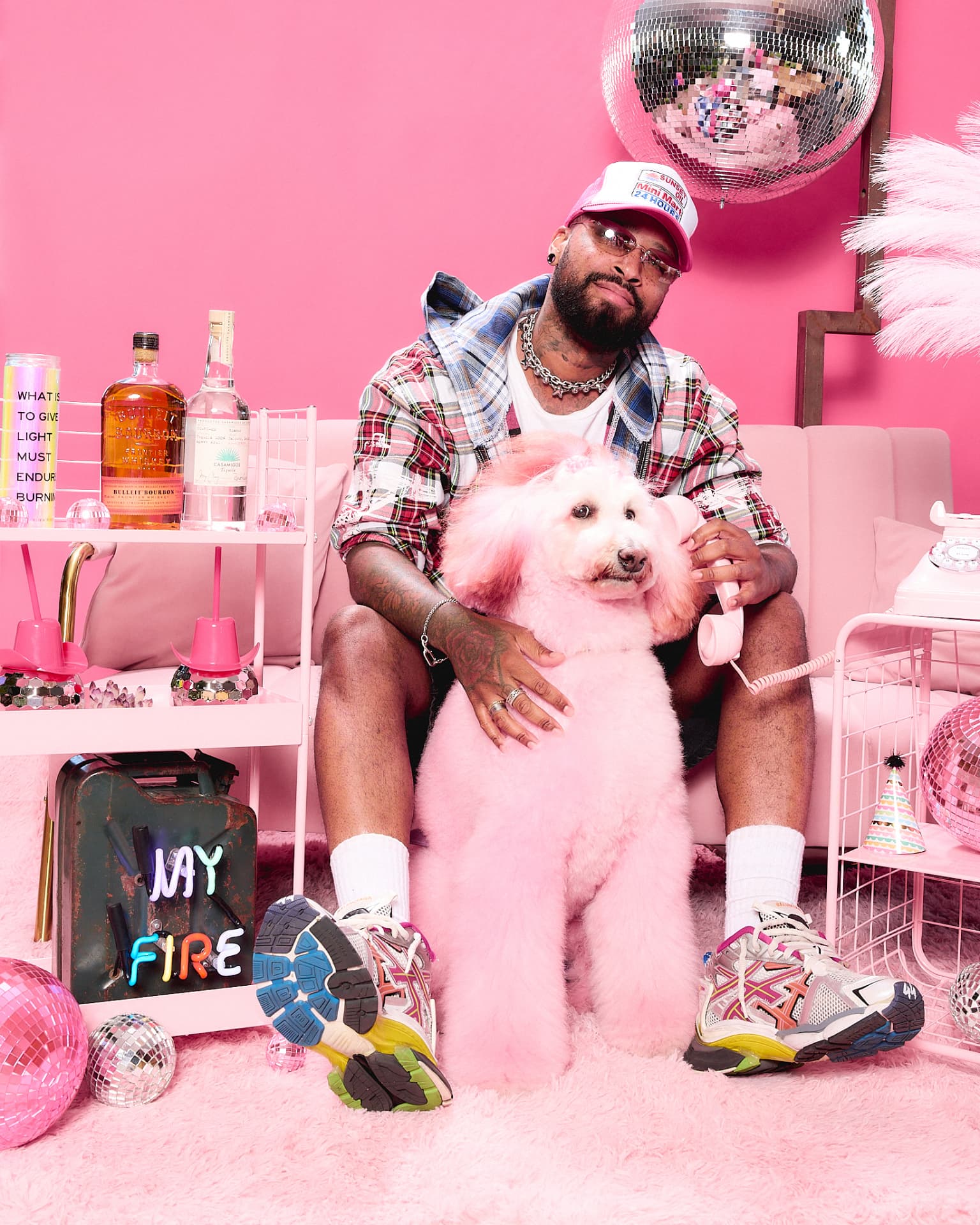 Pet parent with dog dyed pink holding a pink telephone