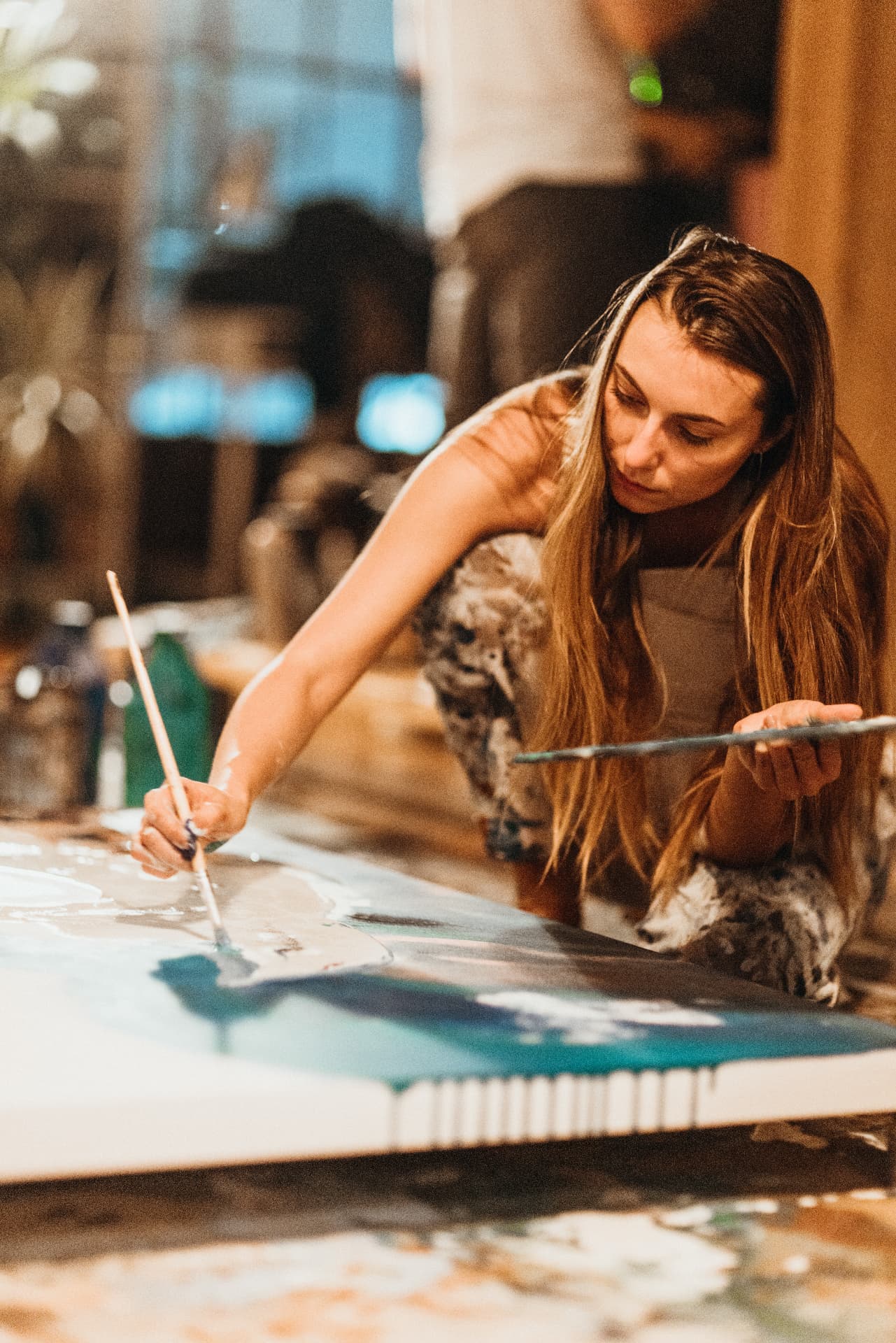 Painter working on a large abstract canvas with her dog beside her