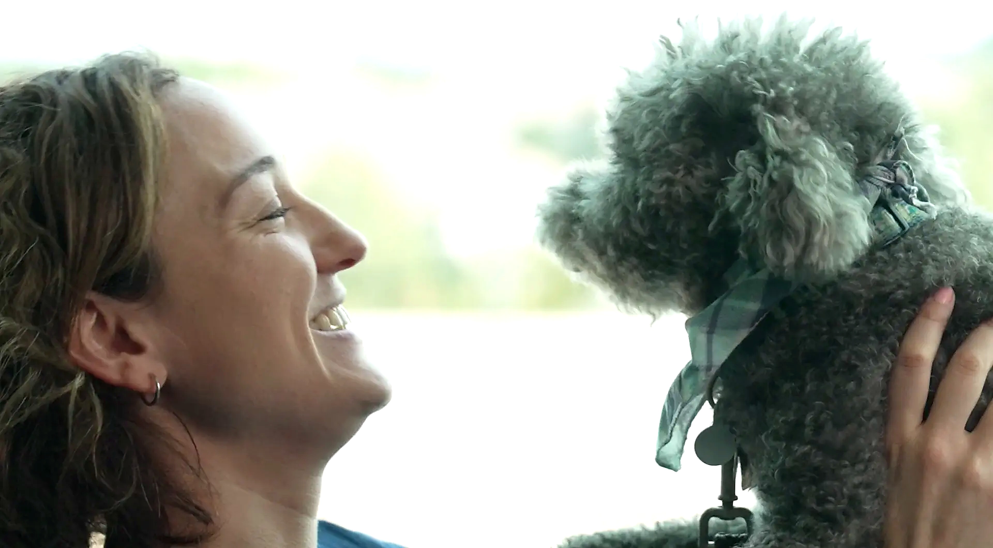 Mars associate laughing with her poodle