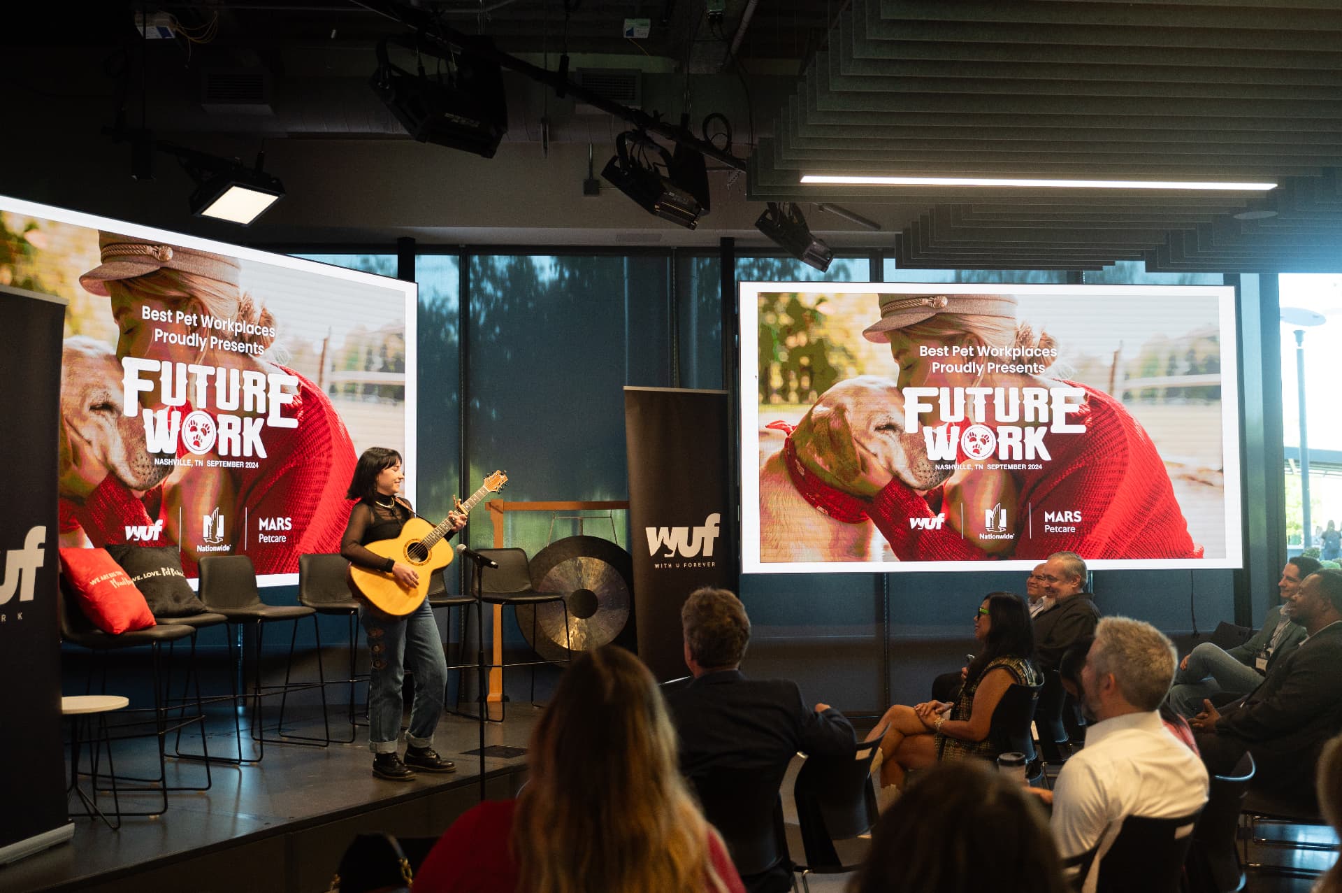 Musician performing on stage in front of the Future Work screens