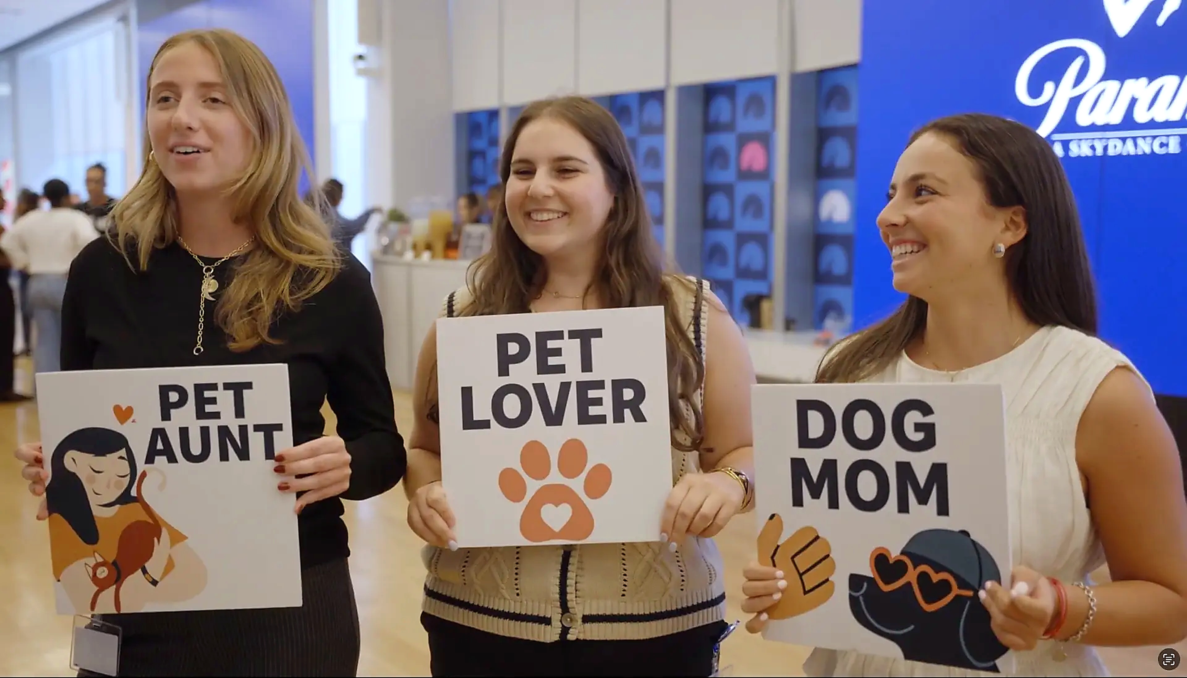 Paramount employees holding Pet Aunt, Pet Lover and Dog Mom signs