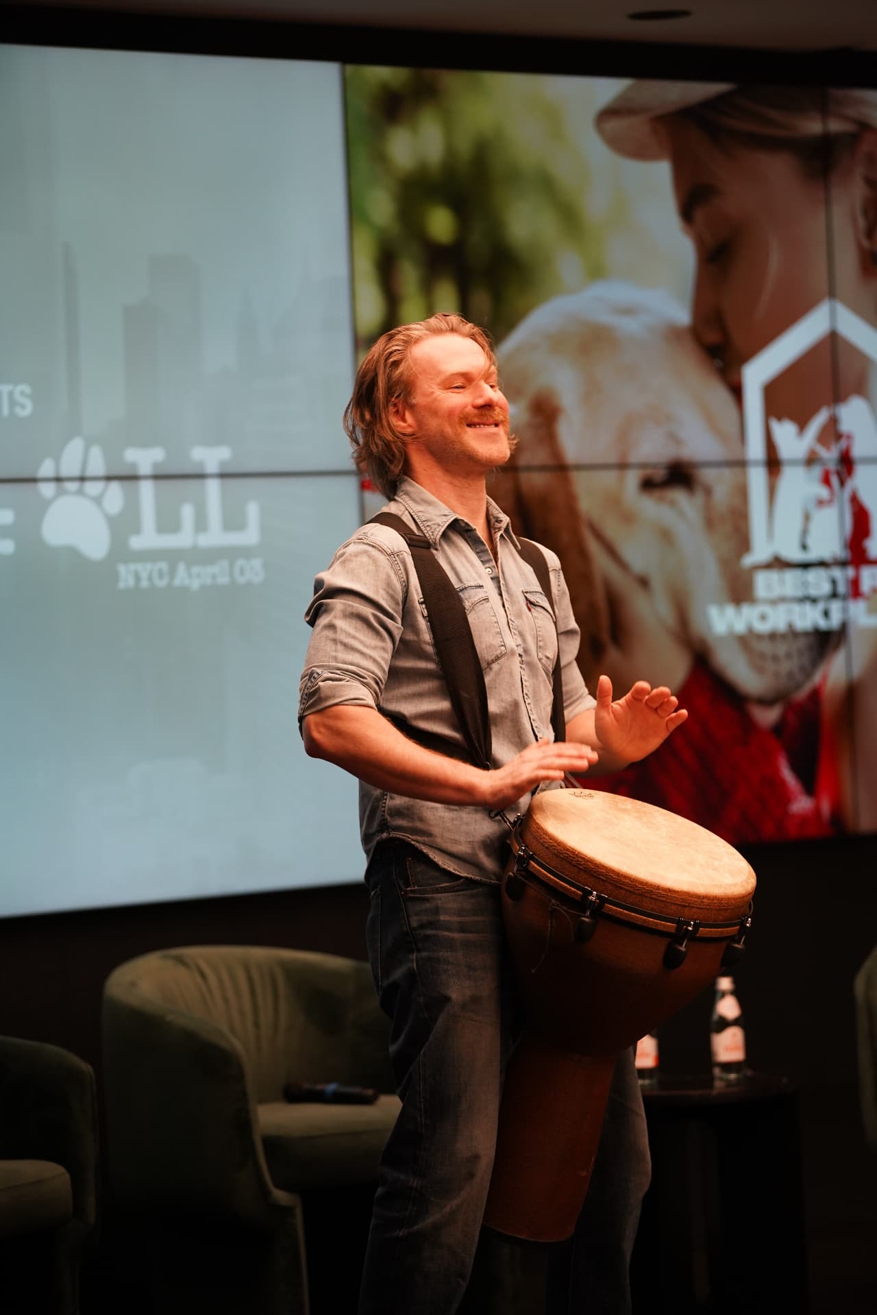 Musician playing a djembe on stage at the summit opening