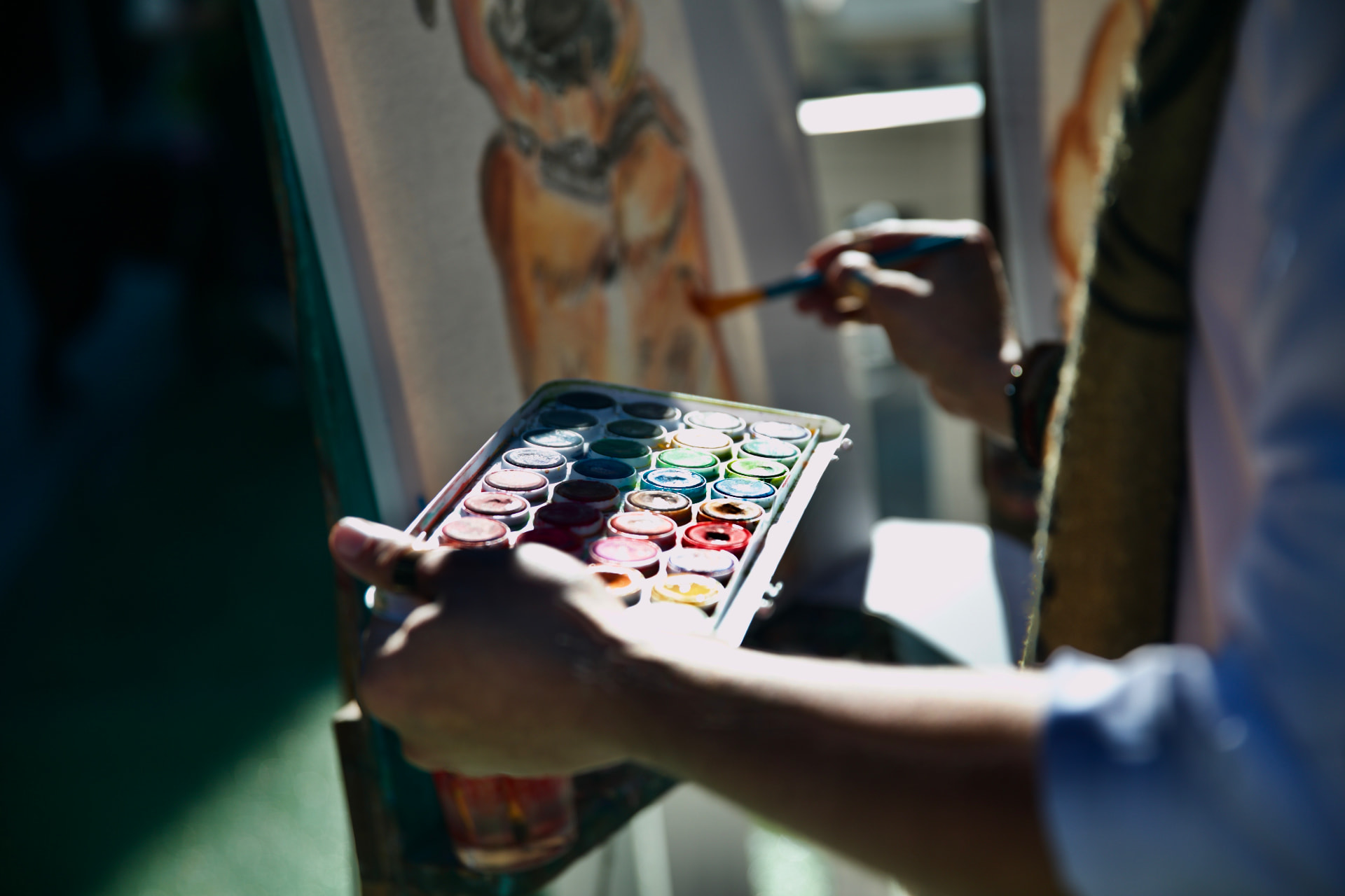 Close-up of a watercolor palette as an artist paints a dog portrait
