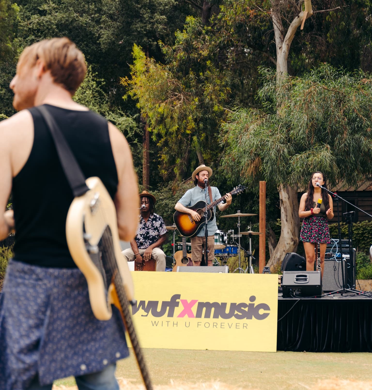 Live band performing on the WUFxMUSIC stage with hay bales in the foreground